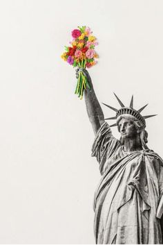 the statue of liberty is holding flowers in her hand