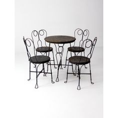 four wrought iron chairs and a round table