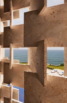 the view from inside an adobe building looking out at the ocean and beach in the distance