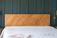 a bedroom with green walls and wooden headboard