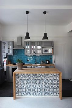 a kitchen with blue tiles and wooden counter tops