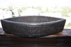 an old wooden bowl sitting on top of a window sill