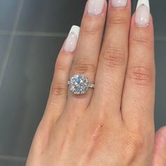 a woman's hand with a ring on it and a diamond in the middle