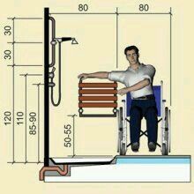 a man in a wheelchair standing next to a shower with the height of his legs