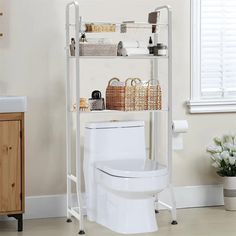 a white toilet sitting in a bathroom next to a shelf with baskets on top of it