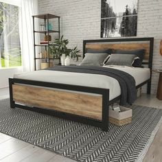 a large bed sitting on top of a wooden floor next to a white brick wall