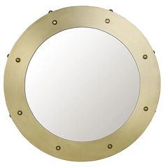 a round mirror with rivets is shown in gold and has a white background