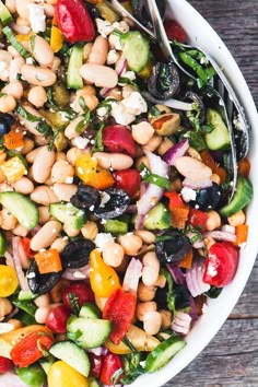 a white bowl filled with lots of different types of food on top of a wooden table