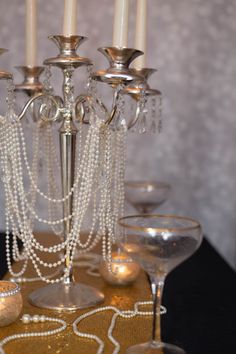 a table topped with lots of candles next to wine glasses