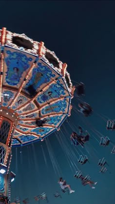 an amusement park ride at night with people riding on the rides and flying in the air