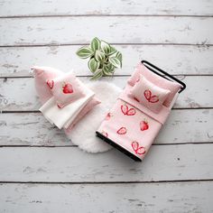 a small potted plant sitting on top of a white wooden floor next to two pieces of cloth