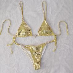 Elegant Gold Swimwear For Beach, Elegant Metallic Swimwear, Gold Swimwear For Beach Party, Fitted Gold Swimwear With Triangle Top, Gold Swimwear For Party And Beach Season, Gold Fitted Triangle Top Swimwear, Fitted Gold Triangle Top Swimwear, Gold Triangle Top Swimwear For Festivals, Gold Fitted Swimwear For Sunbathing