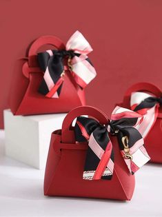 two red purses with black and white bows on them are sitting on a table