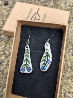 a pair of earrings in a box on the ground