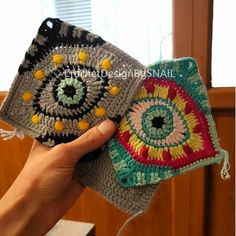 someone is holding two crocheted coasters in their hand