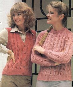 two women standing next to each other wearing sweaters