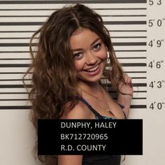 a woman standing in front of a jail cell with her hand on her hip and smiling at the camera