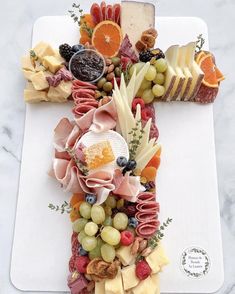 a cross made out of fruits and cheese