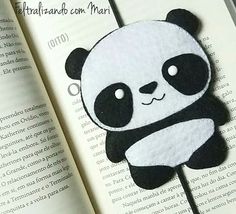 a panda bear brooch sitting on top of an open book