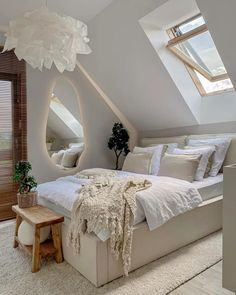 a large bed sitting under a skylight in a bedroom