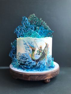 a cake decorated with an image of a man on a surfboard in the ocean