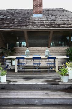 an outdoor dining area with blue chairs and potted plants