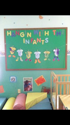 a child's bedroom with a green wall and hanging pictures on the wall above it