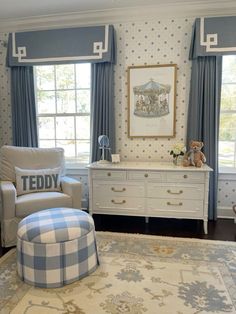 a baby's room with blue and white decor, including a teddy bear on the dresser