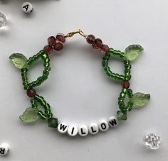 a green beaded bracelet with the word willow written on it and beads surrounding it