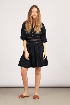 Elevate your style with our Mercy Dress – a blend of elegance and comfort. Crafted from 100% cotton, this mini dress is available in striking blue and classic black. The pleated ruffled skirt adds a playful touch, while the elasticated belt with contrasting stitching details defines your silhouette. Make a statement in our Mercy Dress! Size & Fit Fits true to size, take your normal size Designed to be worn loosely fitted Model is 5’10’’ (1.75 mt) and is wearing a size S Detalis & Care 100% cotton Mini dress Shirt collar V-neckline Buttons on chest to the waist Elasticated belt with stitching details in contrasting colours Long sleeves with detail on dropped shoulders Elasticized cuffs Pleated ruffled skirt Machine wash cold, do not bleach, tumbly dry gentle Casual Knee-length Dress With Ruffled Skirt, Mini Dress With Pleated Waist For Day Out, Pleated Mini Dress For Day Out, Chic Cotton Tiered Dress With Ruffle Hem, Casual Mini Dress With Ruffled Skirt, Chic Cotton Tiered Dress, Cotton Ruffle Dress With Mini Length, Day Out Pleated Tiered Skirt Dress, Cotton Mini Dress With Ruffle Hem For Daywear