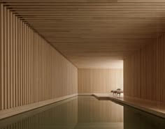 an indoor swimming pool with wooden slats on the walls