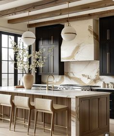 a large kitchen with marble counter tops and black cabinetry, along with wooden flooring