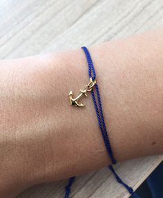 a person wearing a bracelet with an anchor on it