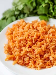 a white plate topped with rice next to greens