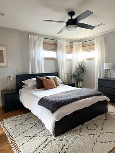 a bedroom with a bed, dressers and ceiling fan in it's center