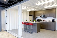 an open kitchen and dining area with bar stools in the middle of the room