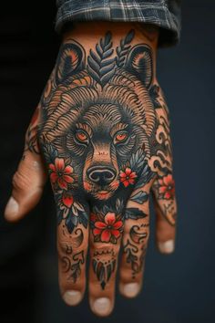 a person's hand with tattoos on it and a bear tattoo on the palm