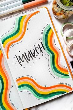 an open notebook with the word march written on it next to some washi tape