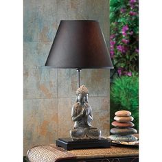 a lamp sitting on top of a table next to a pile of rocks and a vase