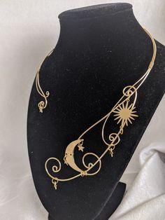 This gorgeous and unique necklace features celestial charms amid swirling vortexes of wire in an elegant torque style. Perfect for special occasions or to add a bit of magic to your everyday! The wire is made of sturdy silver-plated copper wire, and the charms are untreated brass. It measures 8.5 Inches long and 5.5 Inches wide (can be carefully bended to be wider) Adjustable Celestial Wire Wrapped Jewelry, Whimsical Adjustable Gold Necklace, Whimsical Gold Metal Necklace, Gold Whimsical Jewelry With Unique Variations, Adjustable Wire Wrapped Magical Jewelry, Magical Gold Jewelry For Festival, Whimsical Wire Wrapped Metal Jewelry, Magical Gold Metal Jewelry, Wire Necklace