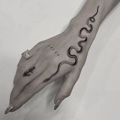 a person's hand with a snake tattoo on it