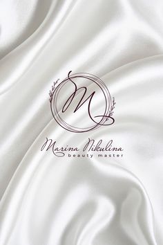 a white satin background with the letter m on it's center and an elegant monogram