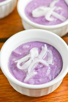 two white bowls filled with purple food on top of a wooden table next to each other