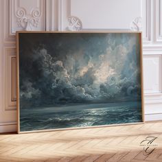 an oil painting of storm clouds over the ocean on display in a white walled room