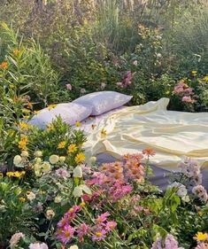 there is a bed in the middle of some flowers