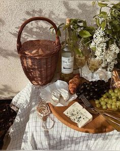 an assortment of cheeses, grapes and bread on a table