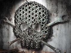 there are wrenches and other tools in the shape of a skull on a wall