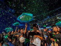 graduates in graduation gowns are throwing confetti into the air at commencement ceremony