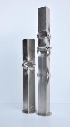 two metal objects sitting side by side on a white surface