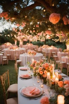 an outdoor dinner table set up with pink flowers and candles